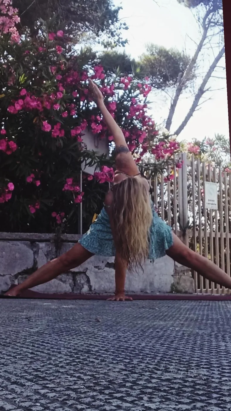 Yoga bland blommande oleander, Linda i en djup stretch-position